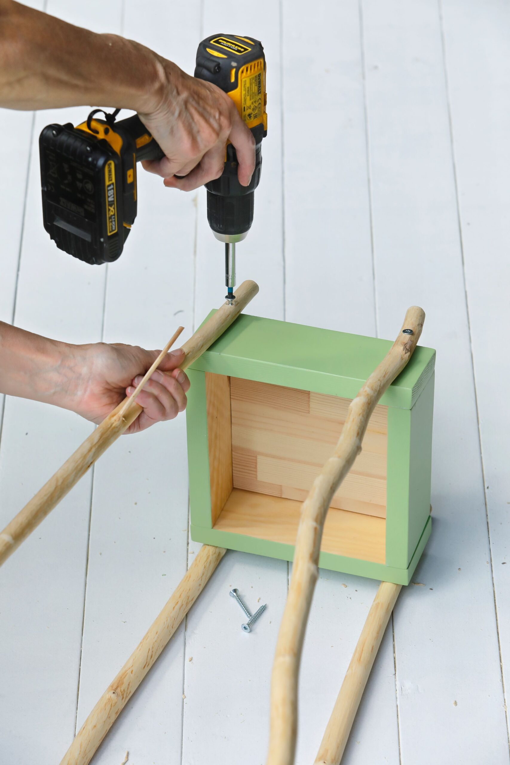 Maalaa kotelo kahteen tai kolmeen kertaan kalustemaalilla. Poraa jalkojen yläosaan esireiät ruuveille. Poraa yläreiät myös kotelon suoriin (ei viistoihin) sivulautoihin. Kiinnitä jalat ruuvein.