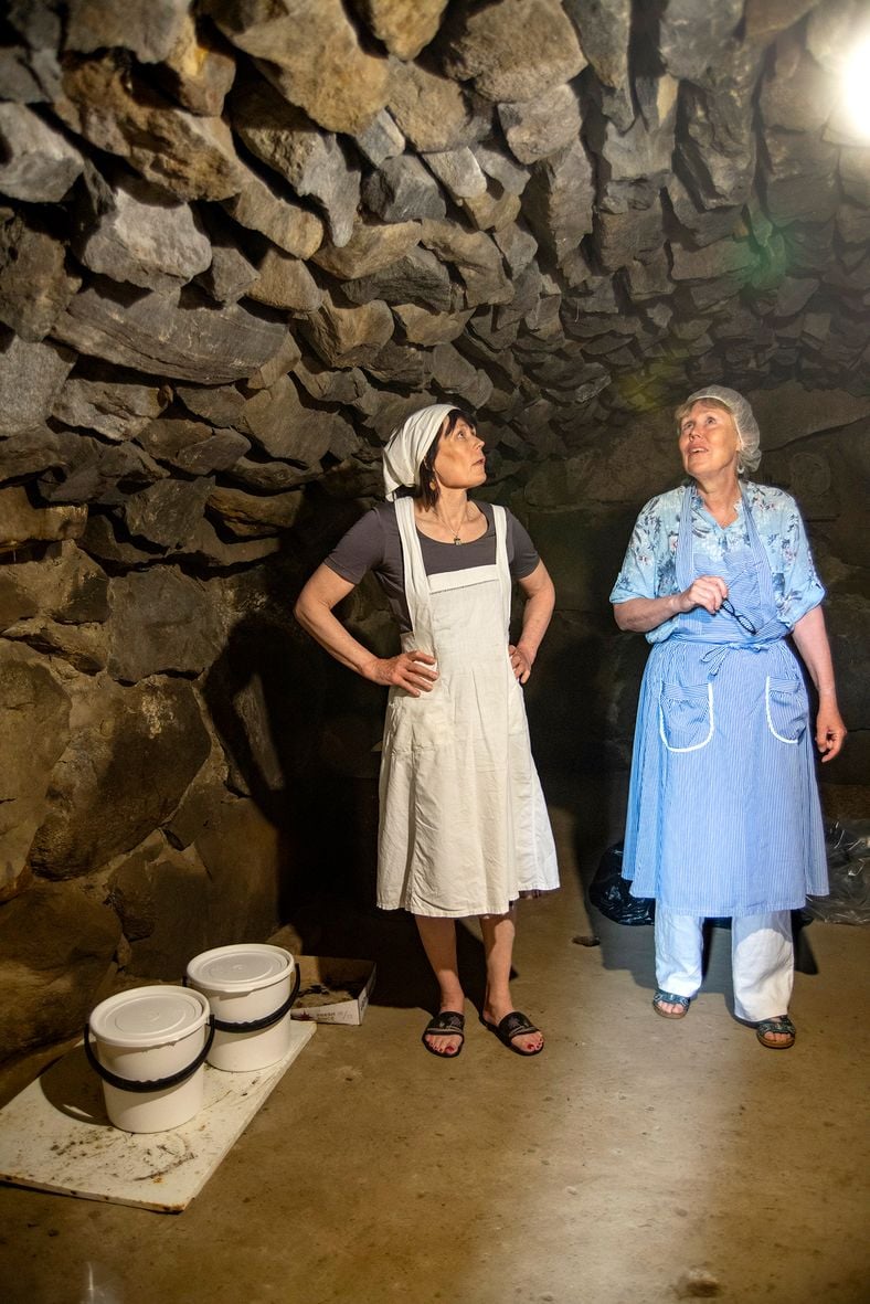 Helena ja Tarja hakevat maitoa kellarista Karjaisen tilan päärakennuksen alta.