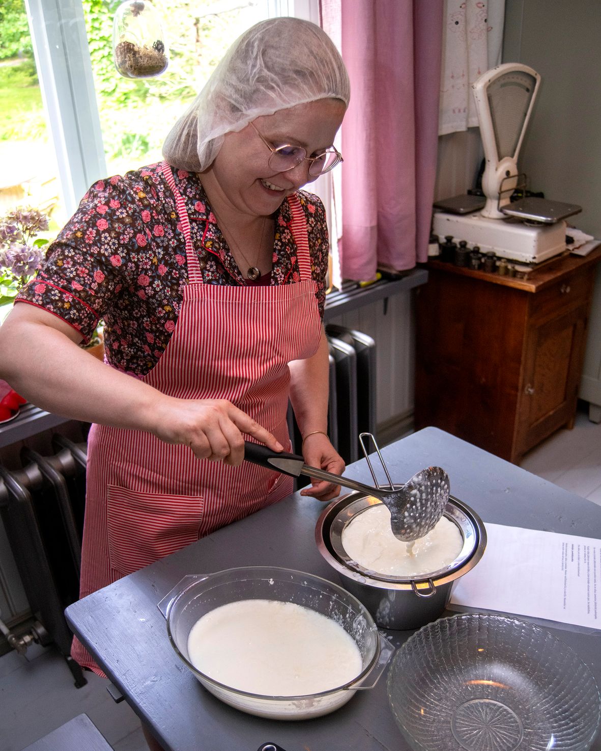 Henna nostaa uunista tulleen rahkan siivilään valumaan.